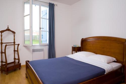 1 dormitorio con cama y ventana en Madame Vacances Les Maisons de Fontenelles, en LʼAiguillon-sur-Vie