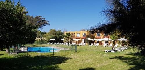 un complejo con piscina, sillas y un edificio en Stellamar Apart Hotel, en La Serena