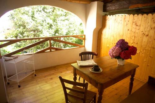una camera con tavolo in legno e vaso di fiori di Le Camelie a Brissago Valtravaglia