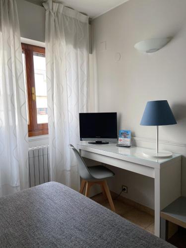 a bedroom with a desk with a computer on it at Hotel Rio Arga in Zaragoza