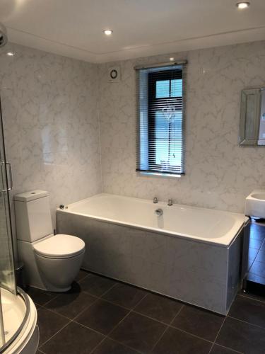 a bathroom with a tub and a toilet and a sink at Little Hermitage in Detling