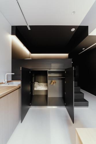 a kitchen with black cabinets and a staircase at Owntown Apart Hotel in Kyiv