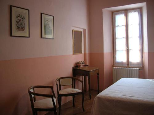a bedroom with two chairs and a bed and a table at Le Camelie in Brissago Valtravaglia