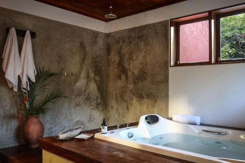 a bathroom with a large tub in a room at Villa Vermelha - Altos de Trancoso in Trancoso