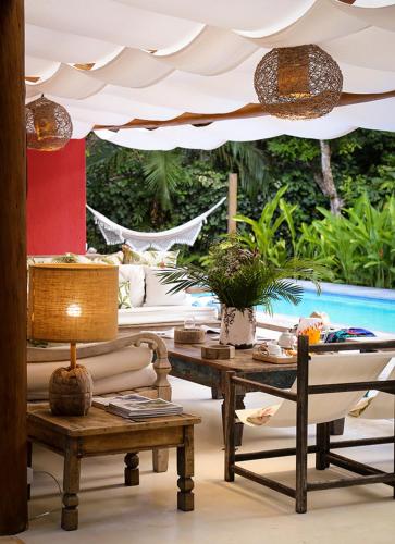 a patio with a table and chairs and an umbrella at Villa Vermelha - Altos de Trancoso in Trancoso
