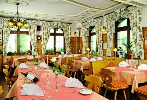 ein Esszimmer mit Tischen, Stühlen und Fenstern in der Unterkunft Hotel Restaurant Zum Hirschen in Donaueschingen