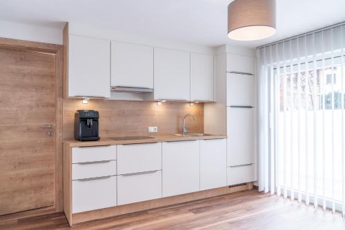 a kitchen with white cabinets and a window at Apart Crystal in Längenfeld