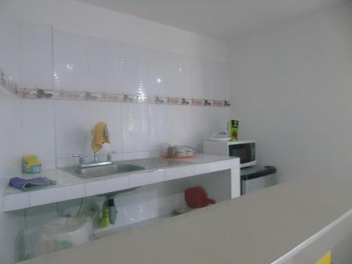 a white kitchen with a sink and a microwave at Posada Miss Joyce House in San Andrés