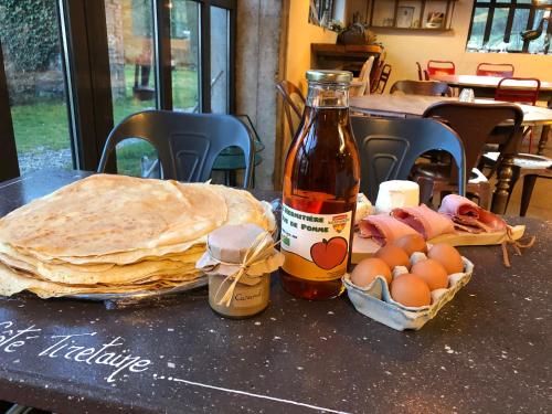 a table with pancakes and eggs and a bottle of sauce at Coté Tiretaine in Orcines