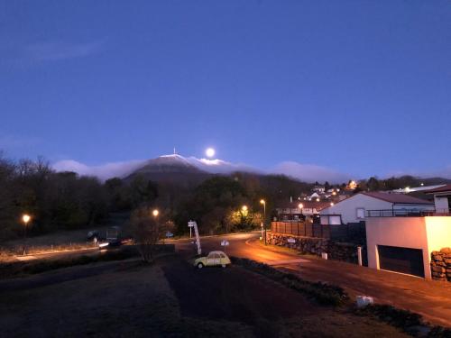 - une vue sur la montagne avec une voiture garée dans une rue dans l'établissement Coté Tiretaine, à Orcines