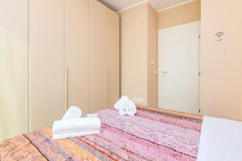 een slaapkamer met een bed met handdoeken en een spiegel bij Appartamento Faelmo Luxury in Sirmione