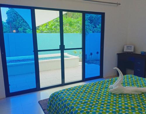 a bedroom with a bed and large glass windows at Chez Melanie Valencia Dumaguete GetAway in Valencia