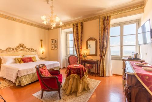 a bedroom with a bed and a table and chairs at Hotel Villa Marsili in Cortona