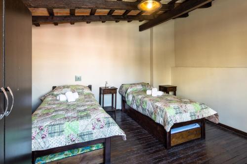 a room with two beds and two tables at APART LA VIÑA in Salta