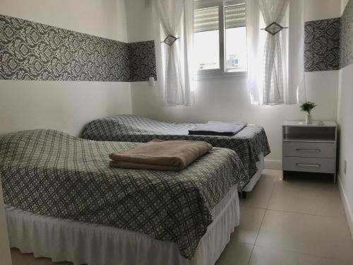 1 dormitorio con 2 camas, vestidor y ventana en Apartamento Maravilhoso em Florianópolis na Praia dos Ingleses com piscina, en Florianópolis