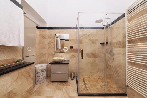 uma casa de banho com uma cabina de duche em vidro e um lavatório. em The Central Retreat - Premium Enjoyment em Arad