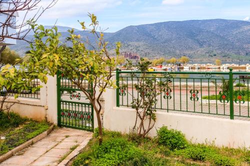 a fence with a mountain in the background at Villa Elli 2 Beach-front villa with garden in Itea