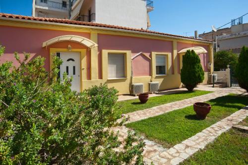a house with a pink and yellow house at Villa Elli 2 Beach-front villa with garden in Itea