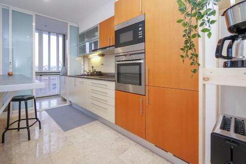 a kitchen with wooden cabinets and stainless steel appliances at Lisbon Best Places - Rooftop in Lisbon