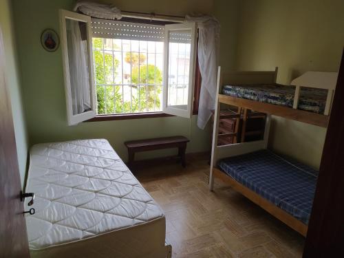 a bedroom with two bunk beds and a window at Chalet Ymaz in Villa Gesell