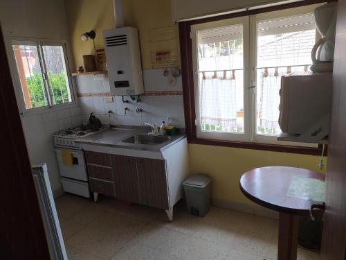 a small kitchen with a sink and a stove at Chalet Ymaz in Villa Gesell