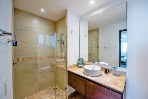 a bathroom with a sink and a glass shower at Tao Chan in Akumal