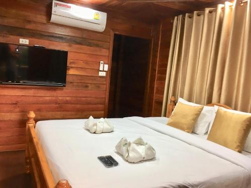 a bedroom with two beds and a tv on a wall at Life and Love house in Ban Na Noi
