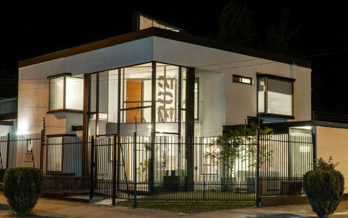 a white house with a fence in front of it at 202 Hotel Boutique in Angol