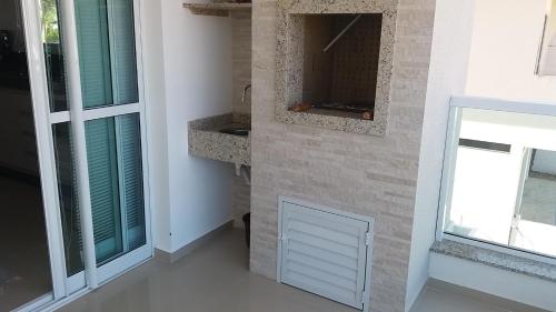 a bathroom with a white door and a window at AP Praia de Palmas in Governador Celso Ramos