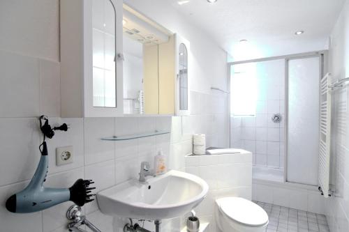 a white bathroom with a sink and a toilet at apartmondo Apartmentwohnungen Remscheid in Remscheid
