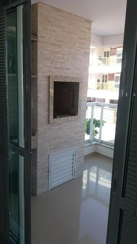 a brick wall with a television in a building at AP Praia de Palmas in Governador Celso Ramos