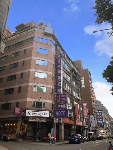 un edificio con cartelli sul lato di una strada di Pai Yueh Hotel a Taipei