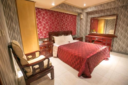 台北市にあるPai Yueh Hotelのベッドルーム1室(ベッド1台、椅子、鏡付)