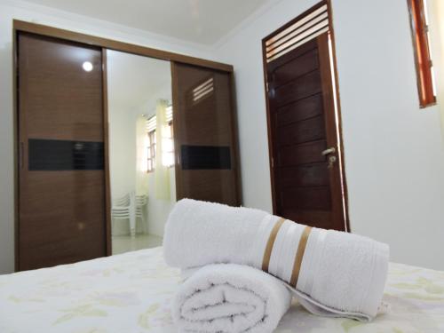 stos ręczników na łóżku w pokoju w obiekcie Pousada Voo Livre Tacima w mieście Tacima