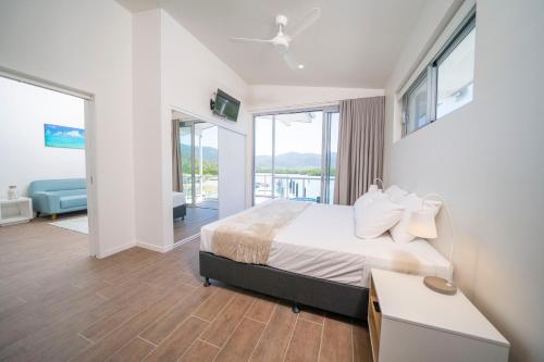 a bedroom with a bed and a large window at Harbour Cove in Airlie Beach