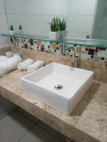 a white sink on a counter in a bathroom at Terraço do Atlântico in Fortaleza
