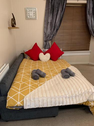 a bed with two slippers on it in a bedroom at Dunfermline GF flat, 5 min walk to Train St. and High St. in Dunfermline