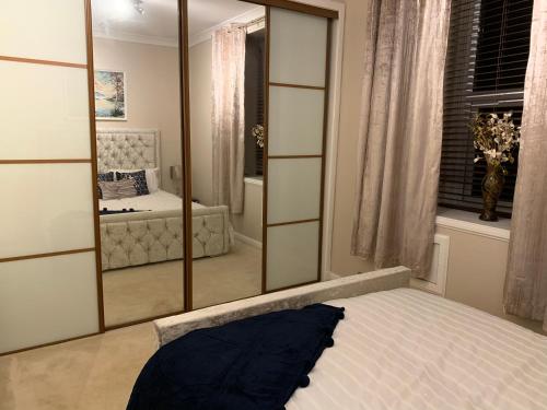 a bedroom with a large mirror and a bed at Dunfermline GF flat, 5 min walk to Train St. and High St. in Dunfermline