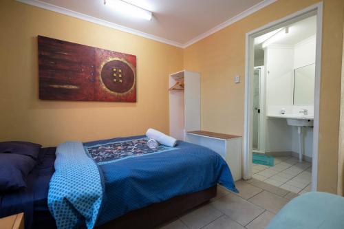 1 dormitorio con 1 cama y baño con lavamanos en Beachside 1770 YHA, en Agnes Water