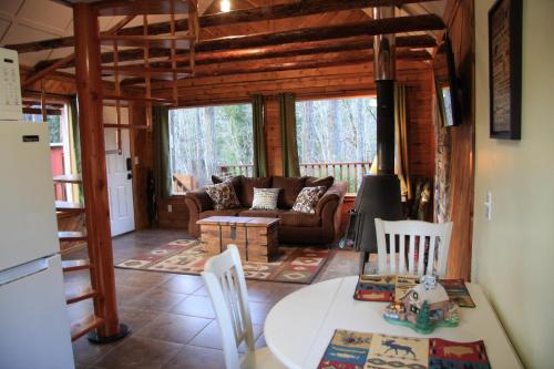 salon z kanapą i stołem w obiekcie Mt Rainier Little Red Cabin w mieście Ashford