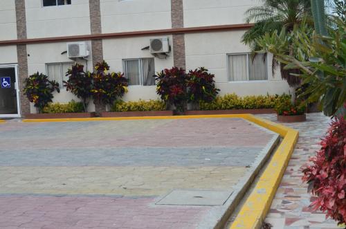 a building with flowers and plants in front of it at Hotel Paradise Beach in Playas
