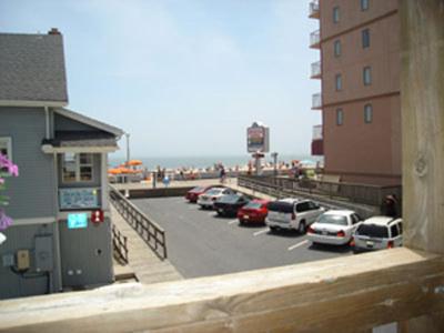 a parking lot with cars parked next to a beach at Beach Walk Hotel in Ocean City