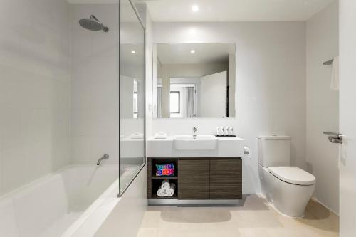 a bathroom with a sink and a toilet and a mirror at Quest Joondalup in Perth