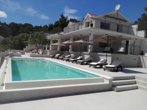 een huis met een zwembad voor een huis bij Apartments Sunny Hvar - with pool; in Basina