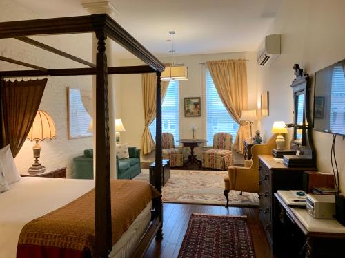 ein Schlafzimmer mit einem Himmelbett und ein Wohnzimmer in der Unterkunft The Barrington in Great Barrington