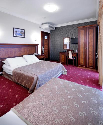 a hotel room with two beds and a desk at Grand Eyuboglu Hotel in Istanbul