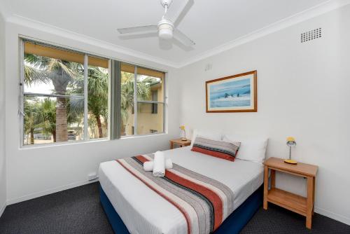 1 dormitorio con cama y ventana en Oxley Cove Holiday Apartment en Port Macquarie