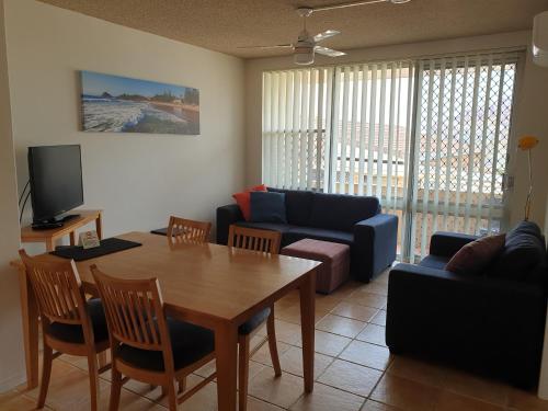 a living room with a table and a couch at Oxley Cove Holiday Apartment in Port Macquarie