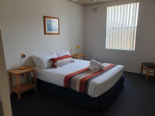 a bedroom with a bed with a laptop on it at Oxley Cove Holiday Apartment in Port Macquarie