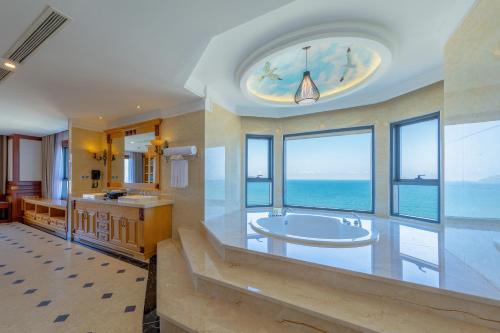 a large bathroom with a tub and a large window at DLG Hotel Danang in Da Nang